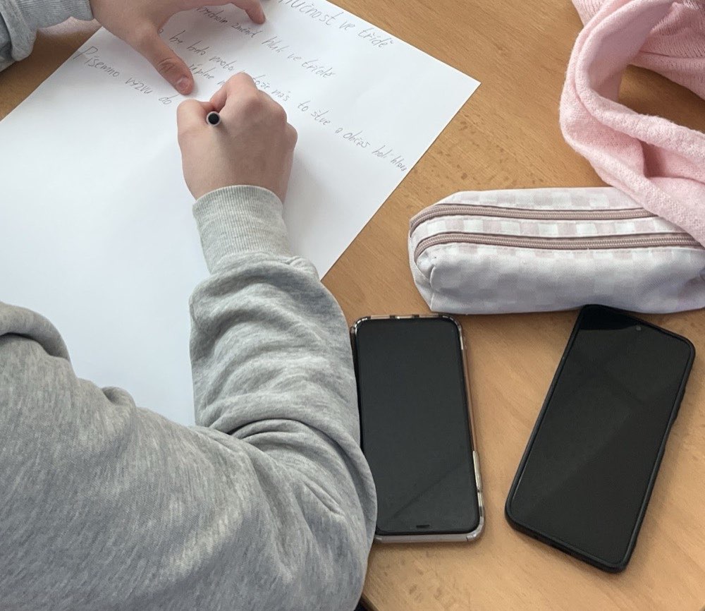 Ruce žáka píšícího na pracovní list